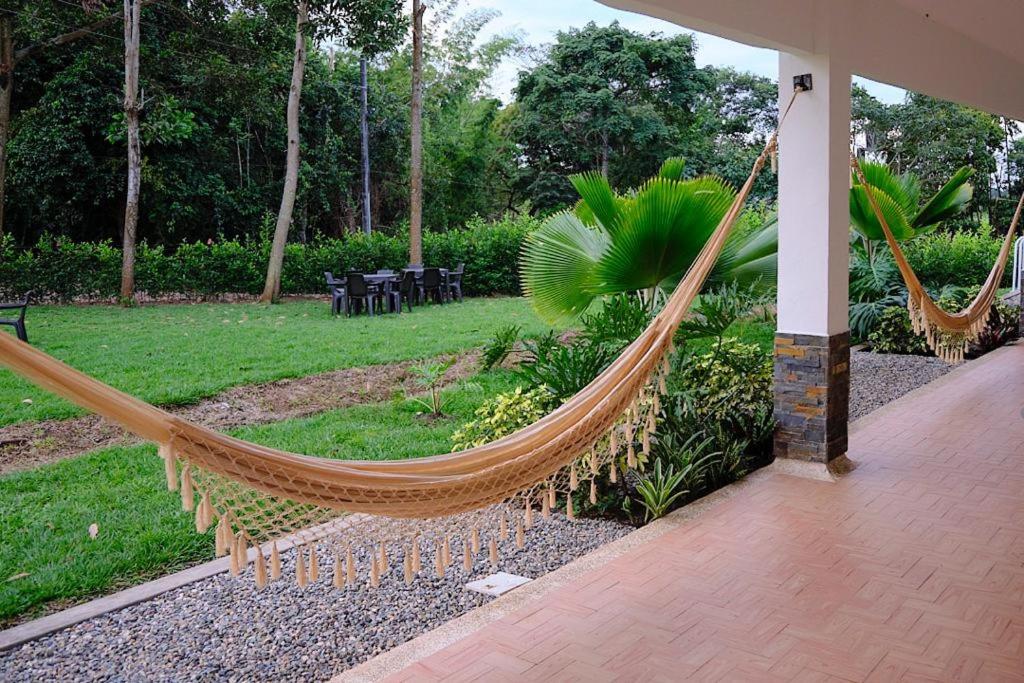 een hangmat in een tuin met een patio bij Casa Finca Soluna in Cumaral