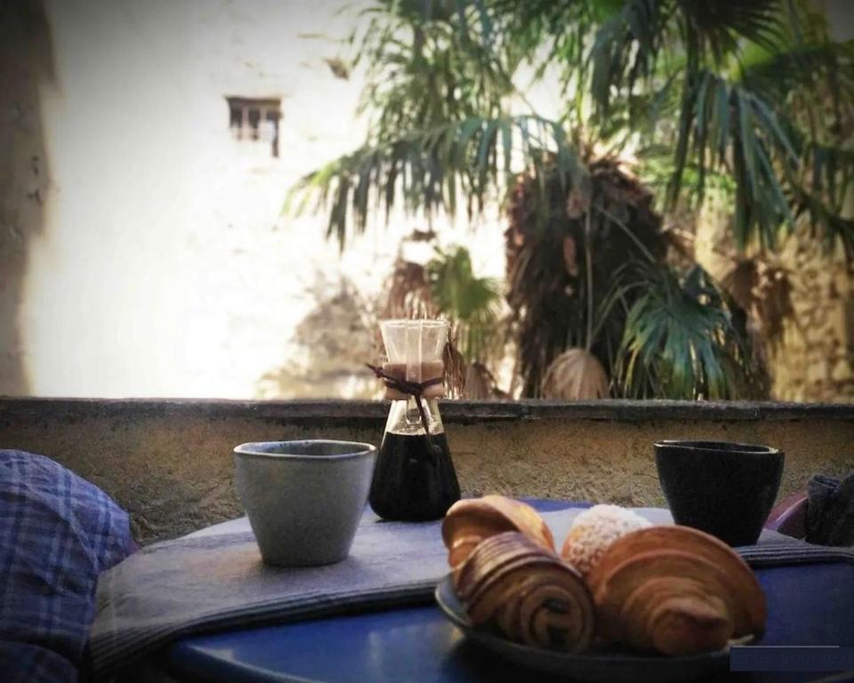 une table avec une assiette de pain et un mixeur dans l'établissement Studio avec terrasse sur cour, authentique, calme, à Avignon