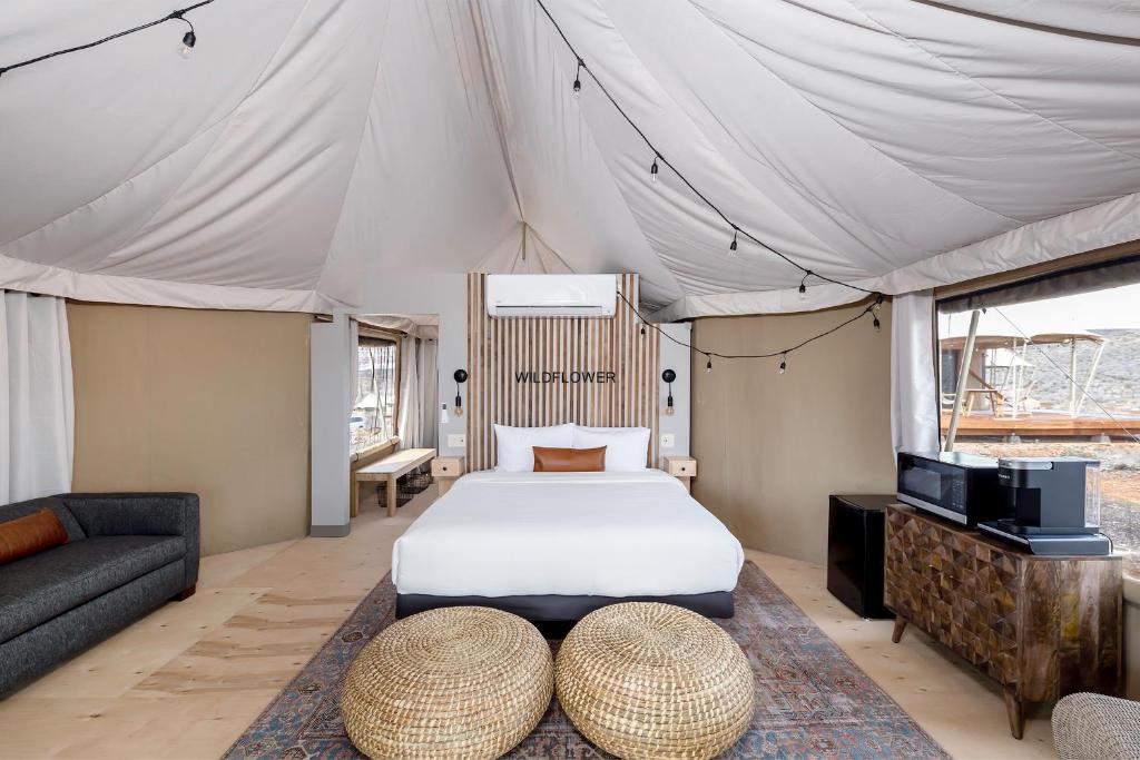 a bedroom in a tent with a bed and a couch at Zion Wildflower Resort in Virgin