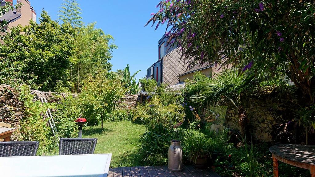 a garden with a table and chairs and plants at maisonnette - quartier viarme in Nantes
