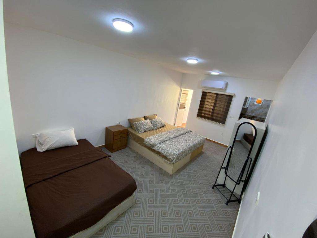 a small room with two beds and a couch at Petra Main Gate Studios in Wadi Musa