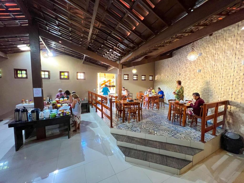 a group of people sitting at tables in a restaurant at Pousada do imperador in Piranhas