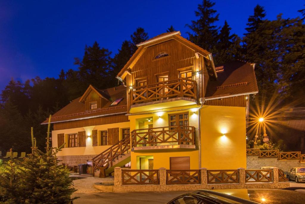 a large yellow house with a balcony at night at Willa Echo in Szklarska Poręba