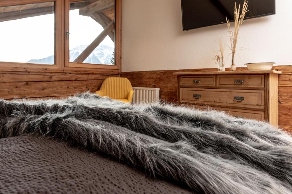 um quarto com uma cama com um cobertor cinzento em Chalet Laugenblick em Santa Valpurga