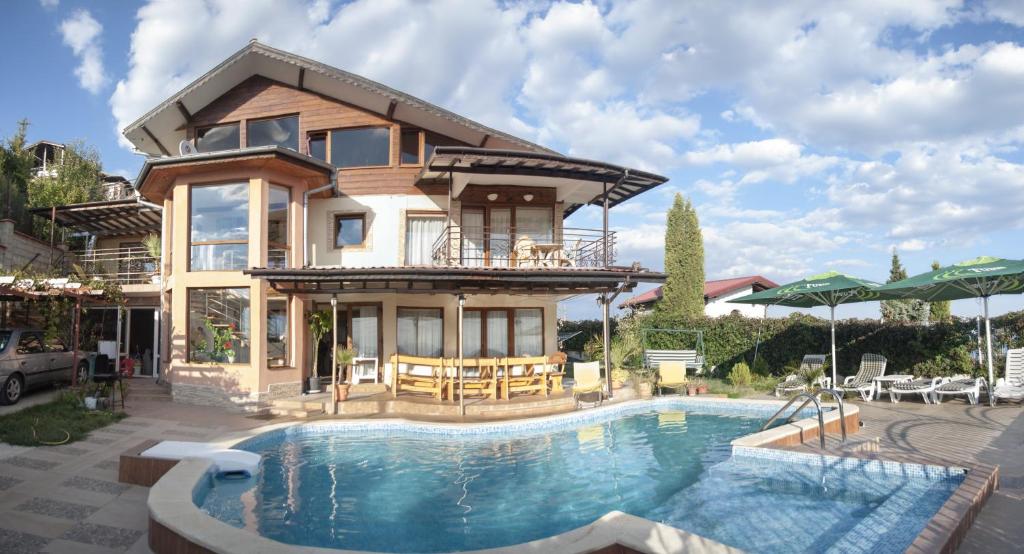 a house with a swimming pool in front of a house at Villa Albena Bay View in Albena