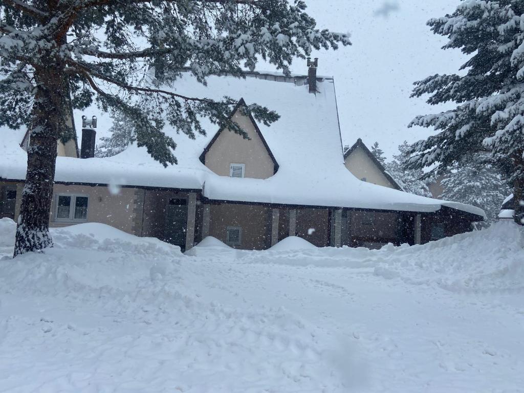 a house covered in snow with a pile of snow at Lake House in Risovac