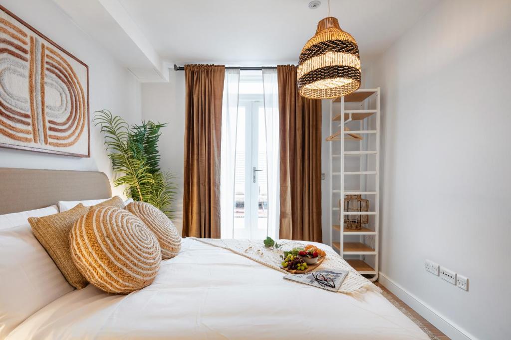 Notting Hill Apartments Collection في لندن: غرفة نوم مع سرير مع طبق من الطعام عليه