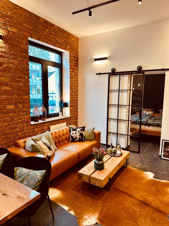 a living room with a couch and a brick wall at holidayAHRpartment in Bad Neuenahr-Ahrweiler