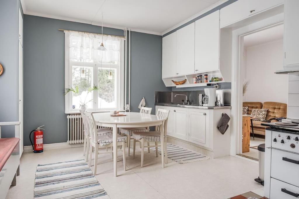 - une cuisine avec une table et des chaises dans la chambre dans l'établissement Rustic home surrounded by forest in Skellefteå, à Skellefteå