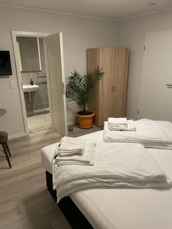 a room with two beds and a bathroom with a plant at Glessener Braustube in Bergheim