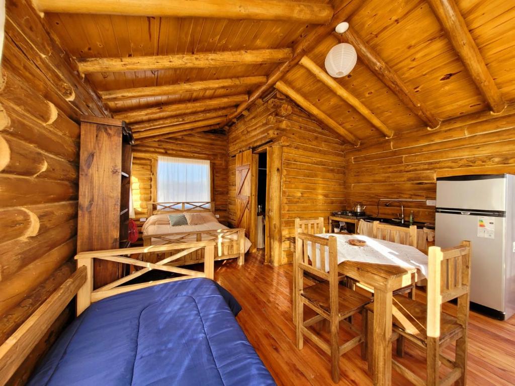um chalé de madeira com uma sala de jantar e uma cozinha em Paramitas - cabañas y hostel de montaña em Uspallata