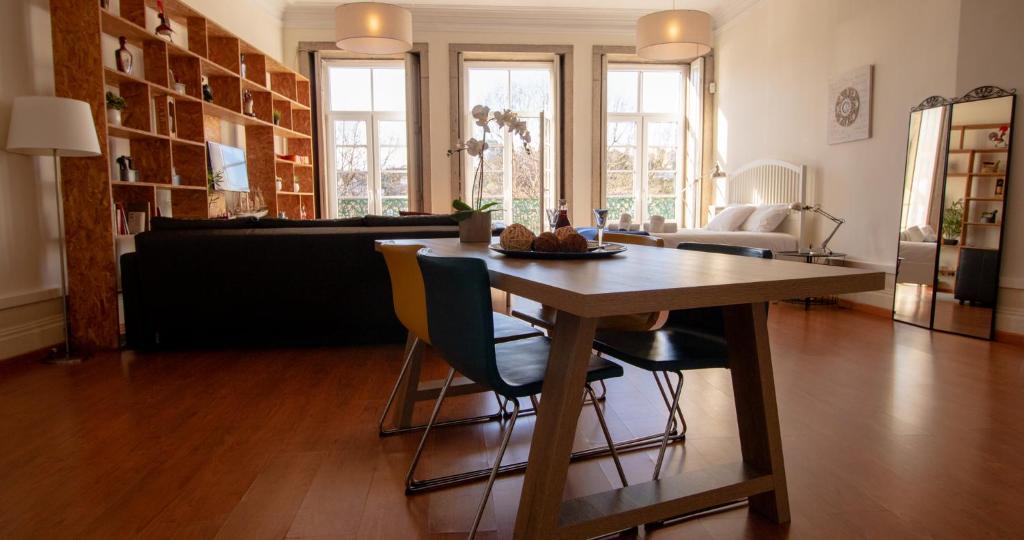 un soggiorno con tavolo e sedie in legno di Casa do Recanto - Loft vista rio a Porto