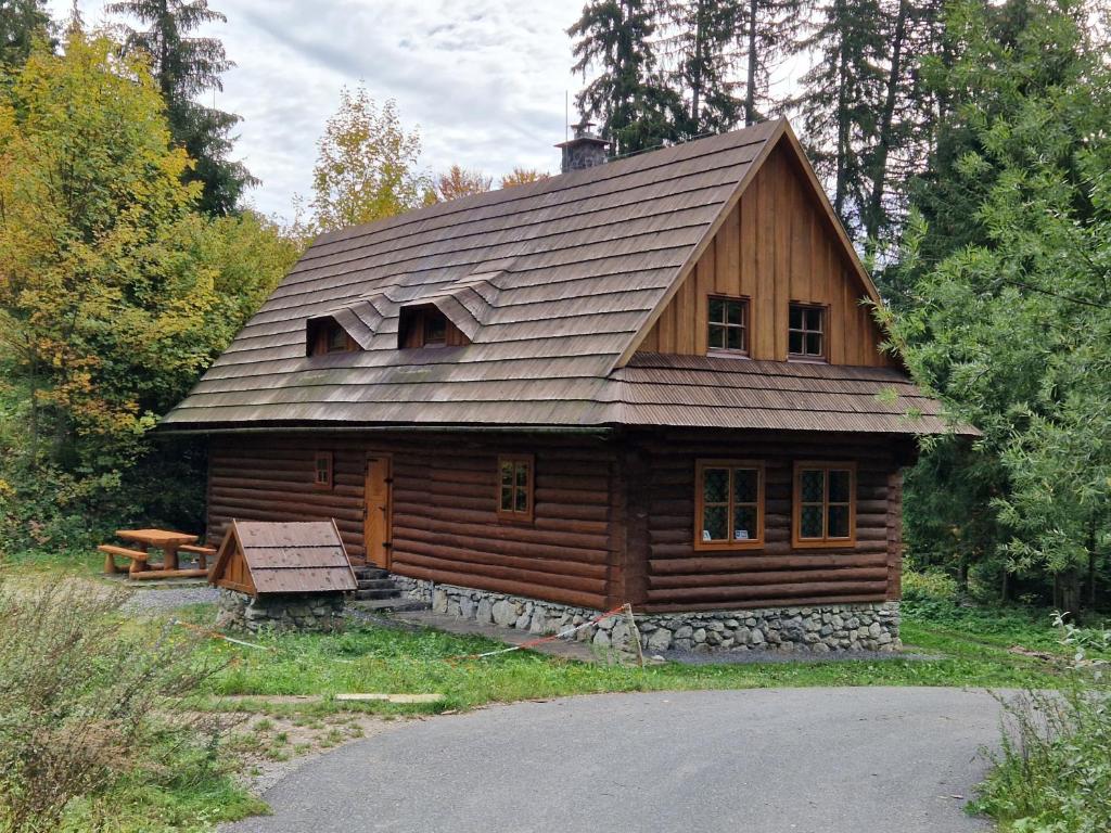 a wooden cabin with a gambrel roof at Chata Bobrovecká vápenica in Bobrovec