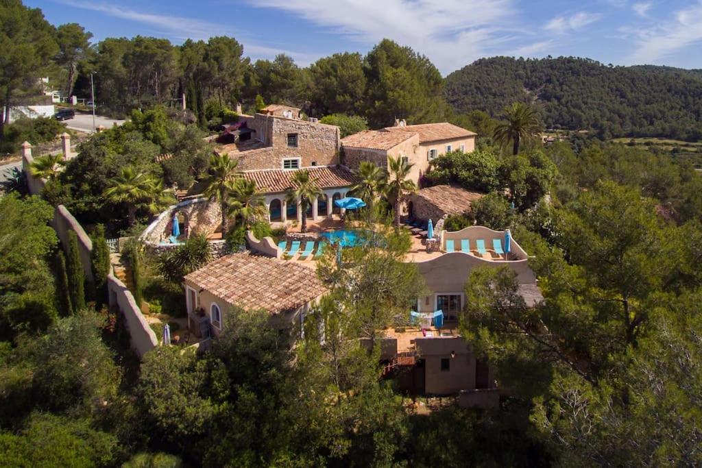 een luchtzicht op een huis met een zwembad bij Sitges Hill Retreats-Masia Nur 22 bedrooms divided over 9 houses for max 44 guests in Canyelles