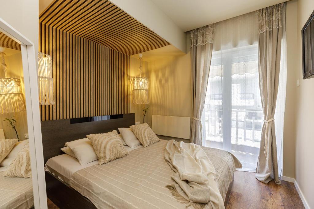 - une chambre avec un grand lit et une grande fenêtre dans l'établissement Sea Stars Apartment 1, à Peraia