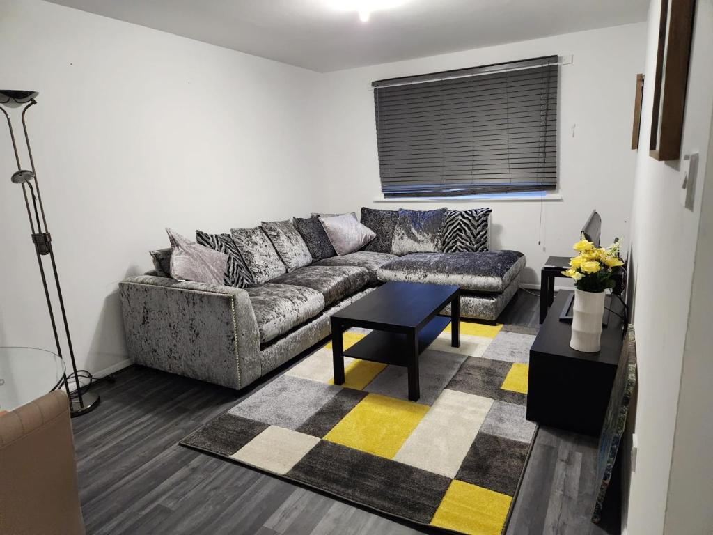 a living room with a couch and a table at 1 bedroom service apartment with Netflix in West Thurrock