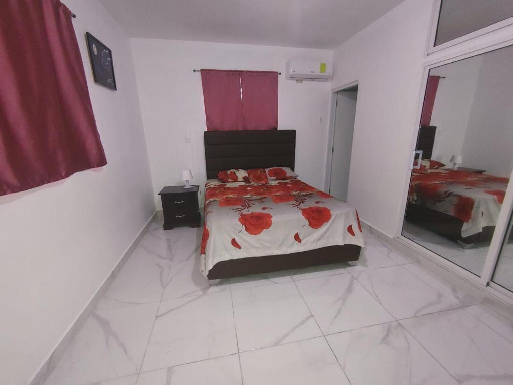 1 dormitorio con 1 cama en una habitación blanca en Apartamento amueblado Res Blue Amber N2, en Santiago de los Caballeros