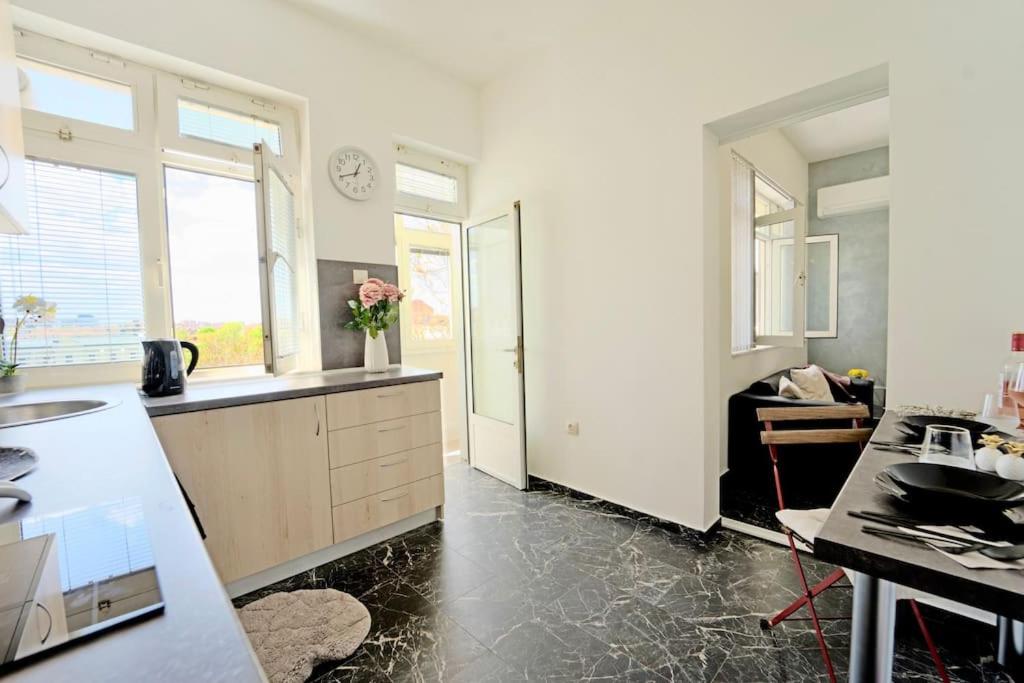 a kitchen with white cabinets and a counter top at Cozy 1-Bedroom flat in the very Center of Sofia in Sofia