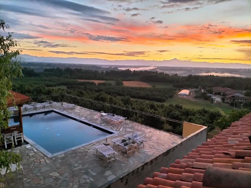 a swimming pool on top of a house with a sunset at Il Palazzetto in Clavesana
