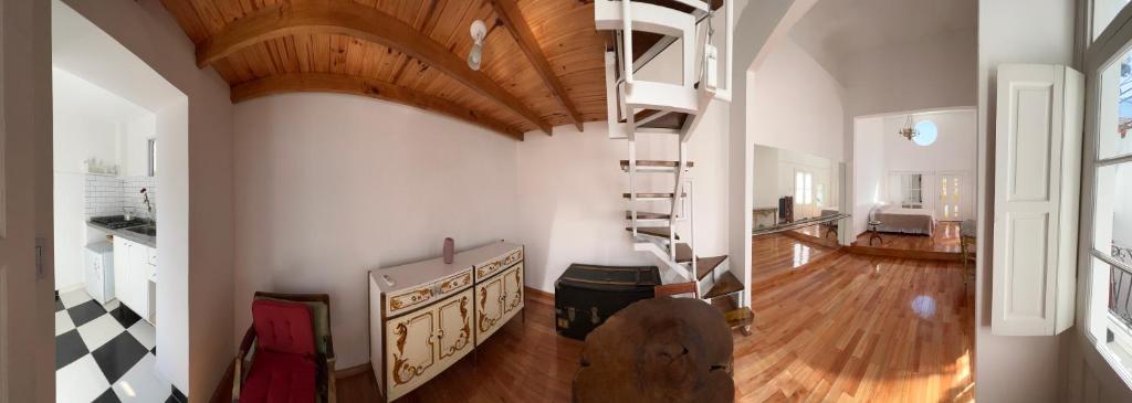 Habitación grande con techo de madera y escalera de caracol. en Enchanting townhouse loft in heart of San Telmo en Buenos Aires