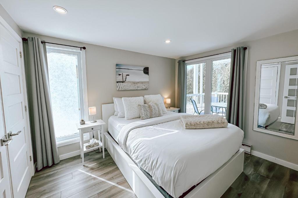 a bedroom with a large bed and a window at L'Intemporel by Gestion ELITE in Mont-Tremblant