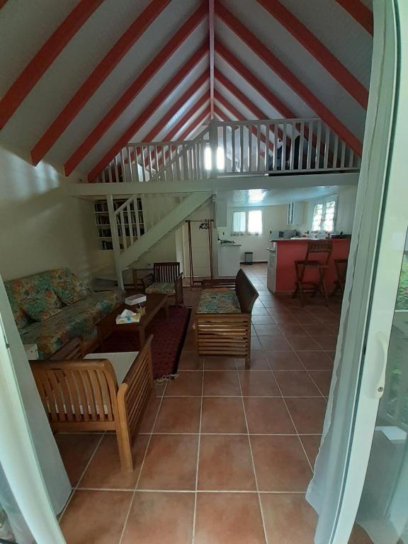 a living room with a couch and a staircase at La petite maison dans la prairie in Gros-Morne