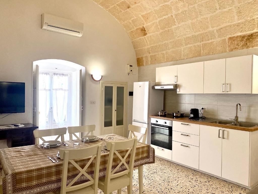 a kitchen with a table and chairs in a room at Dimora Anna - Puglia Mia Apartments in Monopoli