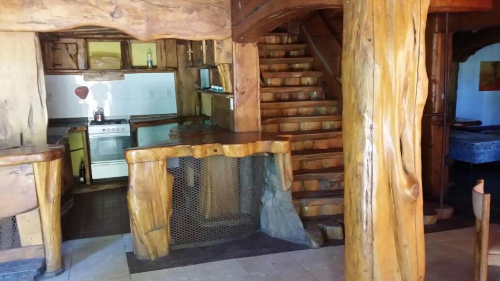 Cabaña de madera con sala de estar con chimenea en Huecubu suites en San Miguel del Monte