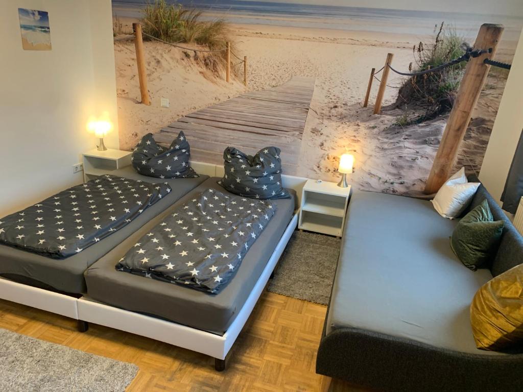 duas camas num quarto com uma pintura de uma praia em Mainpark Apartment 4 Schlafzimmer bis zu 10 Personen direkt über AschaffApartment bei Aschaffenburg em Mainaschaff