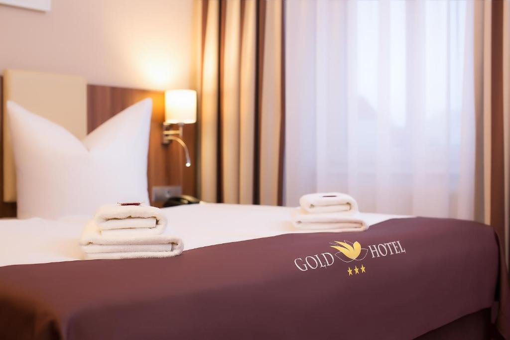 Ein Bett oder Betten in einem Zimmer der Unterkunft Gold Hotel