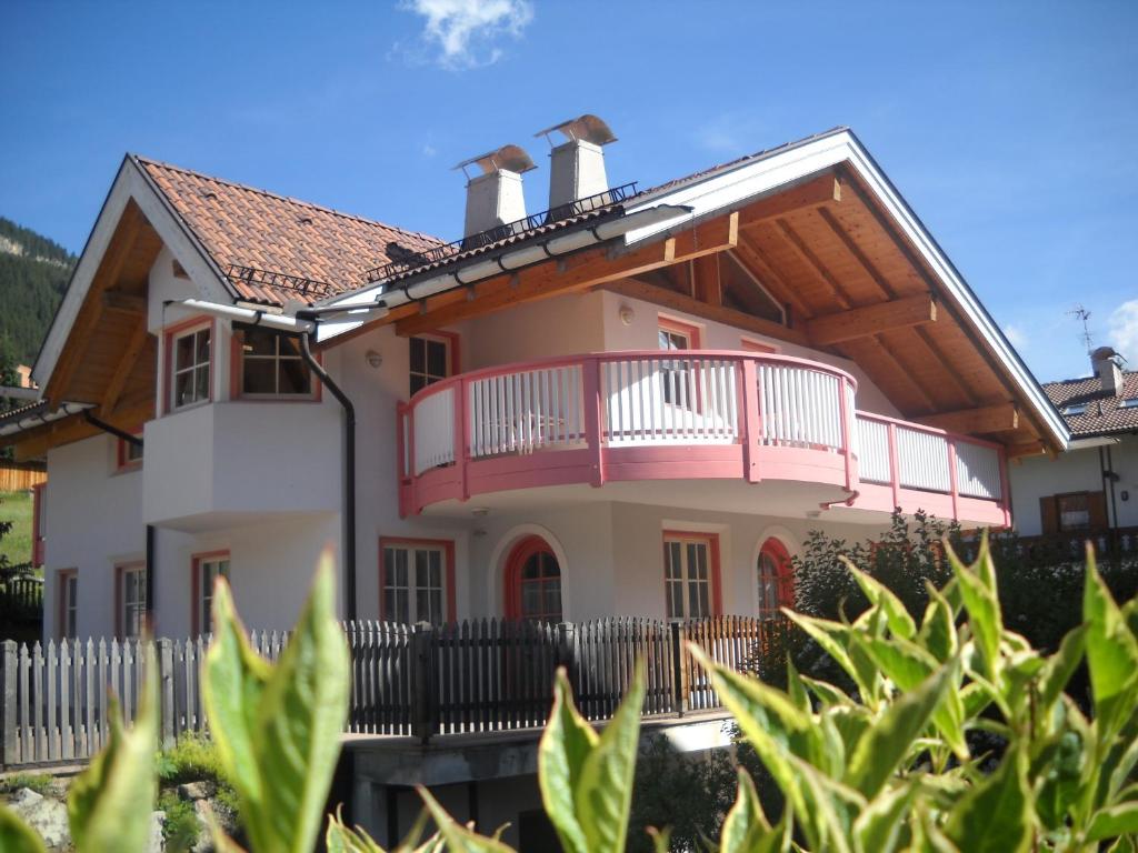 ヴィーゴ・ディ・ファッサにあるVilletta Enrosadiraのピンクのバルコニーとフェンス付きの家