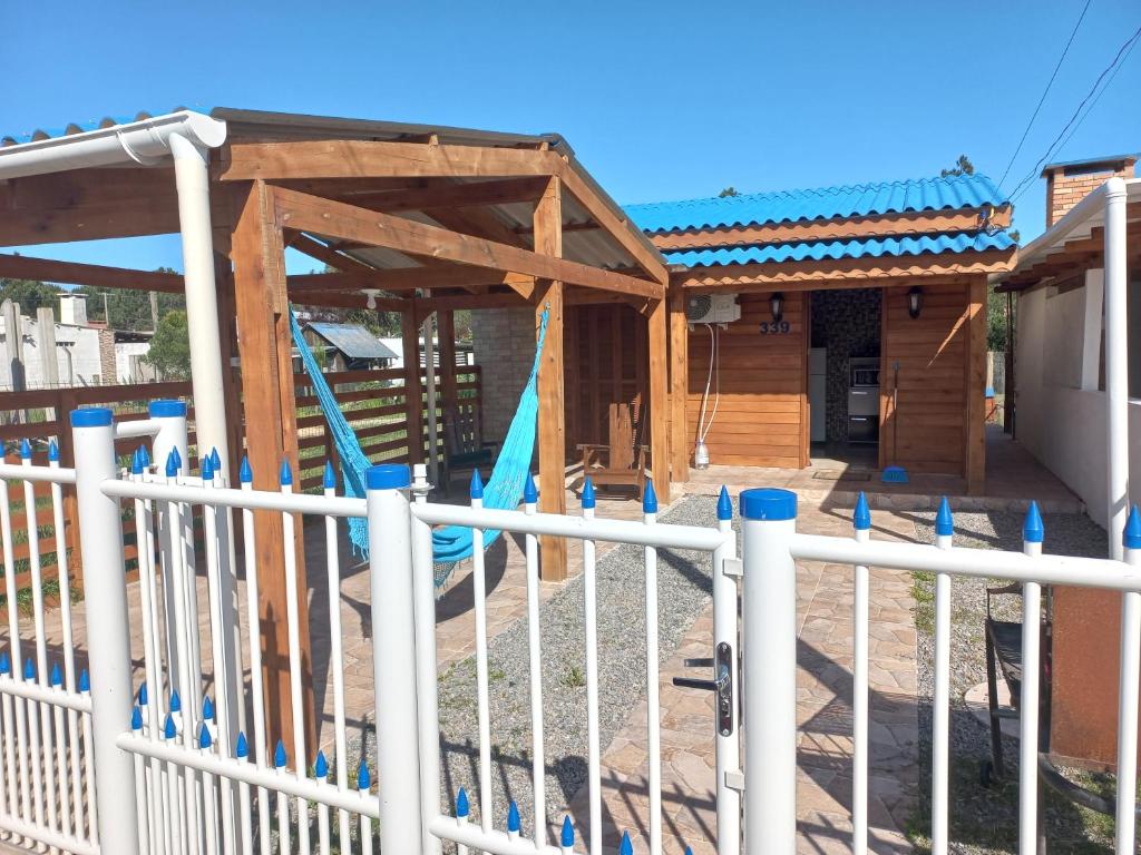 una valla frente a un parque infantil con un edificio en Cabaña a estrenar de 2 dormitorios a 3 km de playa, en Santa Vitória do Palmar