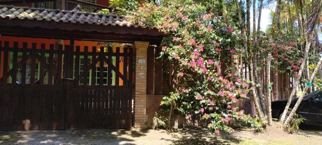 Una casa con una puerta con flores. en Villa São Lourenço, en Bertioga