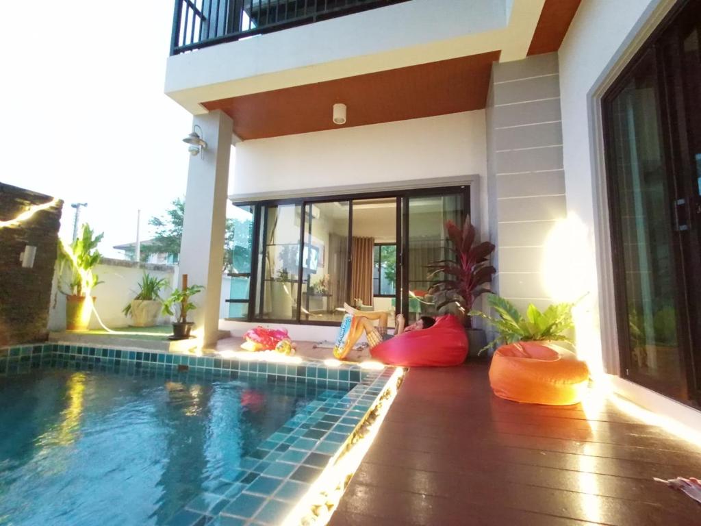une maison avec une piscine en face d'une maison dans l'établissement Richly's​ Pool​ villa​@Phitsanulok​, à Phitsanulok