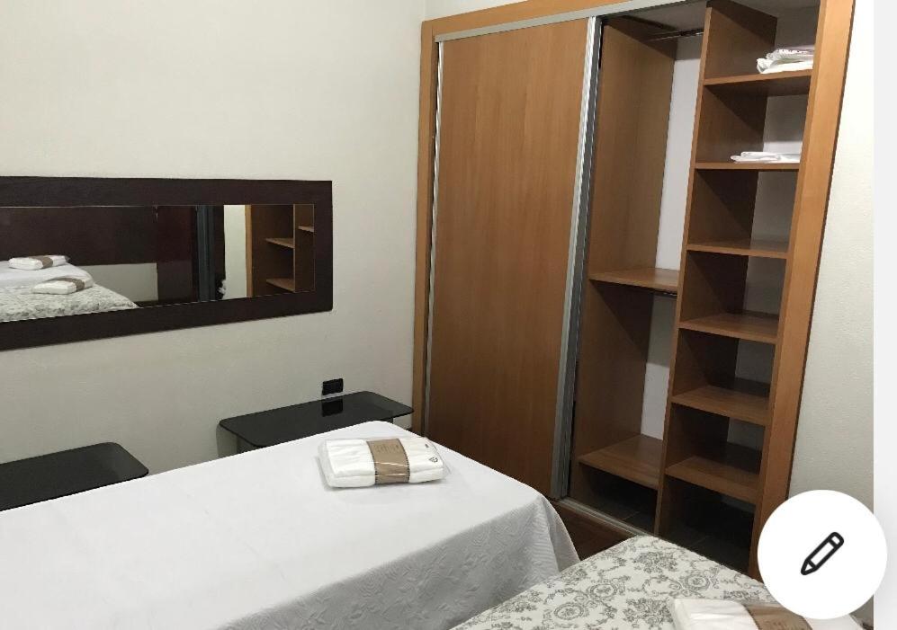 Habitación pequeña con cama y espejo. en Departamento excelente ubicación en La Plata