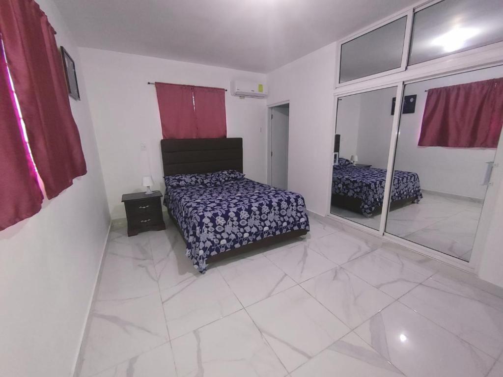 1 dormitorio con cama y espejo en Apartamento amueblado Res Blue Amber N1, en Santiago de los Caballeros