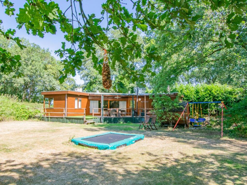 uma casa com um parque infantil em frente em Villa Maashorst em Uden