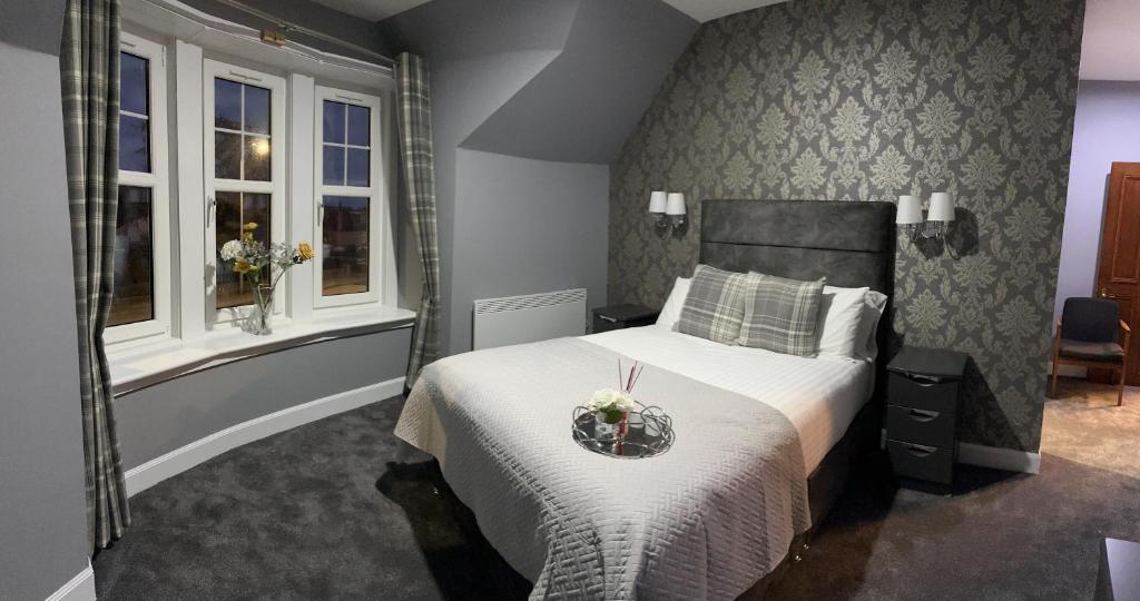 um quarto com uma cama e duas janelas em St Michaels Inn 