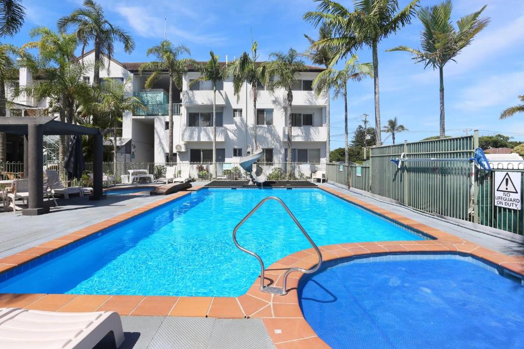 a large blue swimming pool in front of a building at Providence Apartment 5 in Hawks Nest
