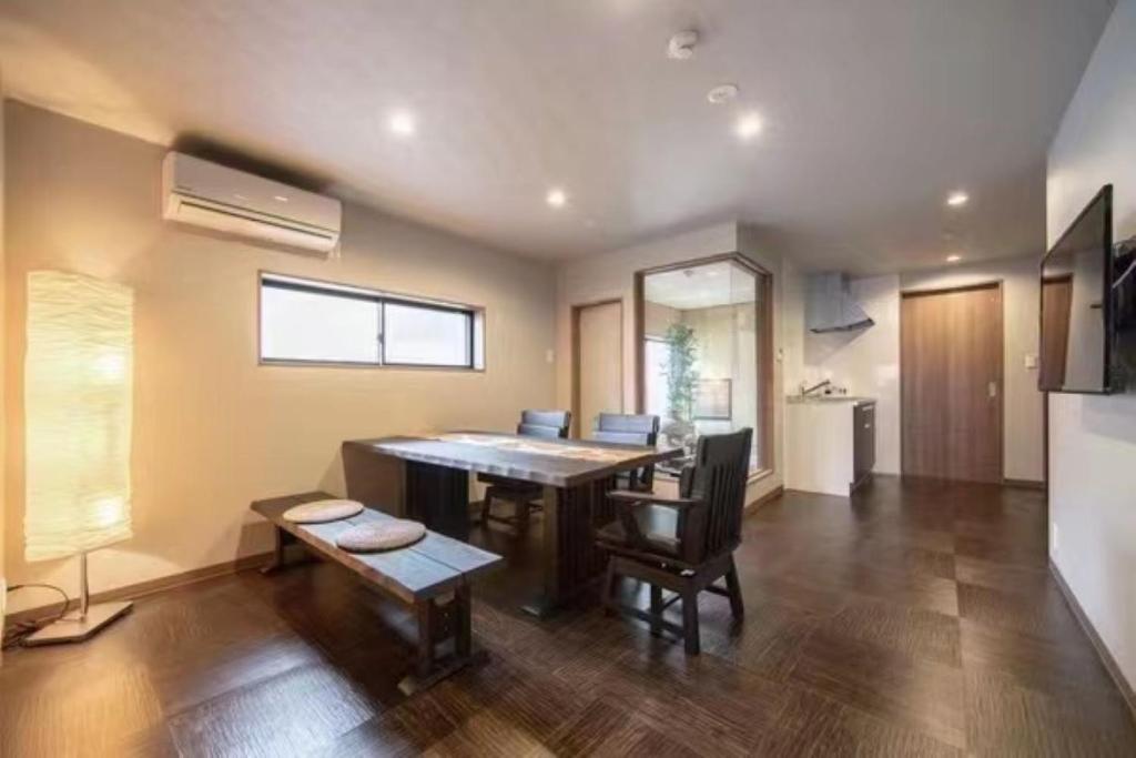 een woonkamer met een tafel en stoelen en een keuken bij Samurai Suite 1 , 15mins from Kyoto Eki , 5 mins to Arashiyama in Kyoto
