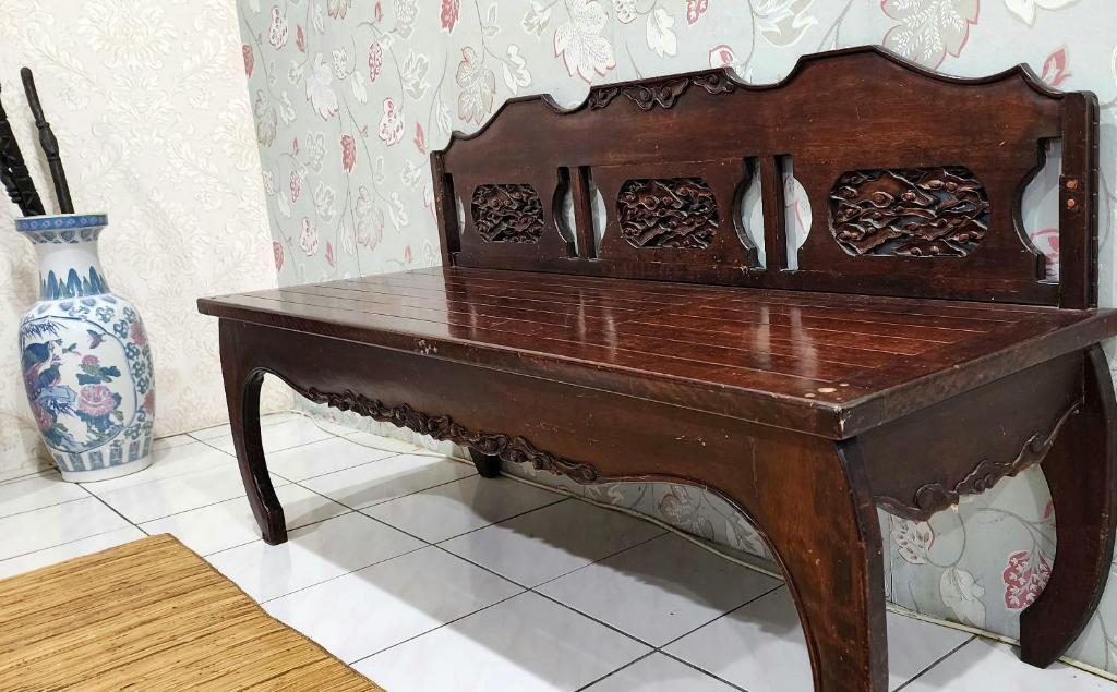 una mesa de madera sentada junto a un jarrón en Tatai Kumang Homestay en Kuching