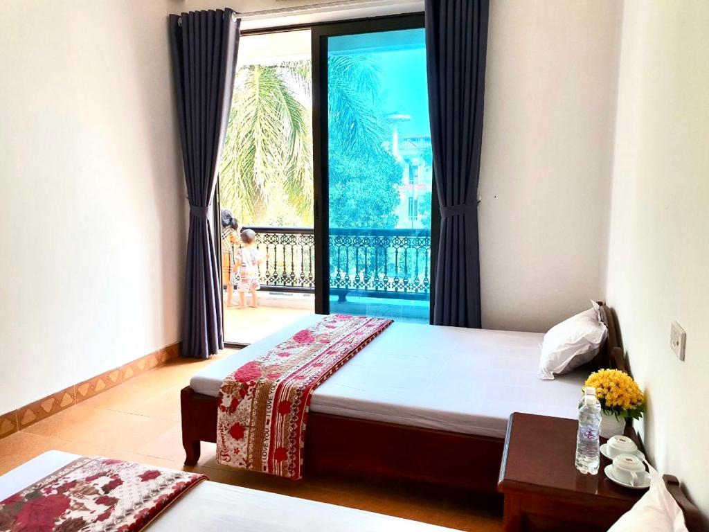 a bedroom with a bed and a large window at Khách Sạn Tuấn Thảo Cửa Lò in Cửa Lò