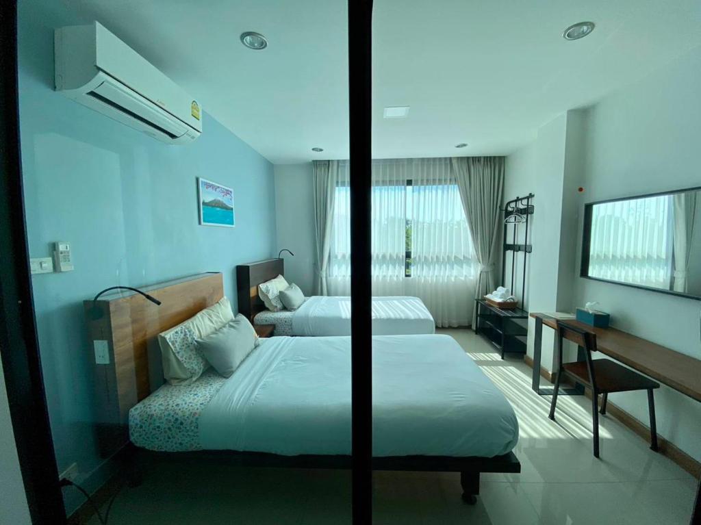 um quarto de hotel com duas camas e uma secretária em แทมมารินด์ em Ban Khlong Tha Thong Lang