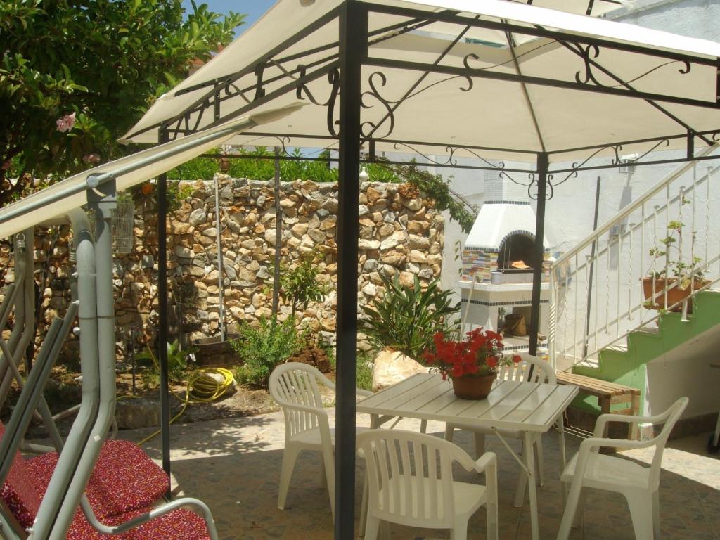 una mesa y sillas bajo una sombrilla en un patio en Villino Claudia, en Porto Cesareo