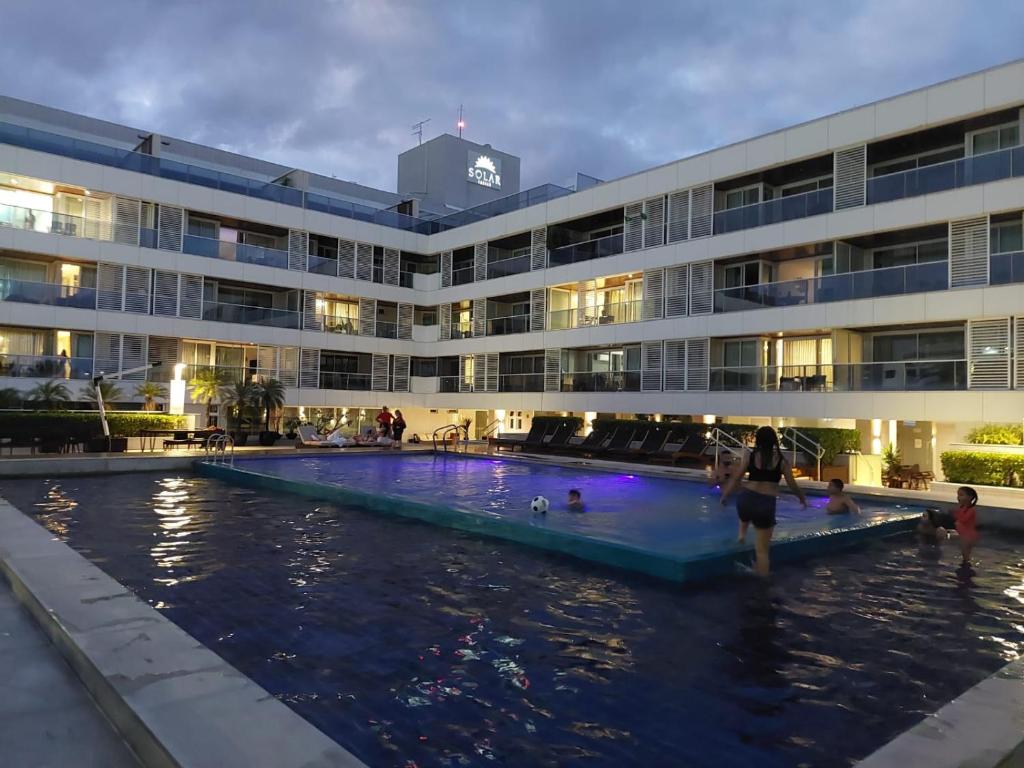 a hotel with a swimming pool in front of a building at Solar Tambaú - Loft sun and sea - ANÚNCIO NOVO in João Pessoa