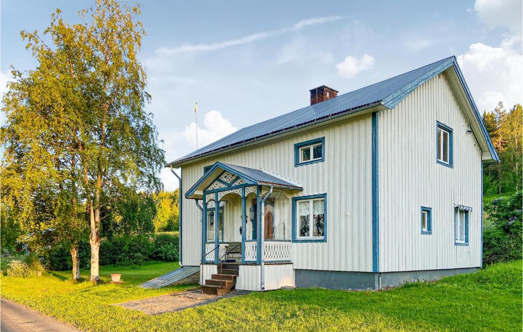 une maison blanche avec des ornements bleus sur une cour dans l'établissement Gorgeous Home In Strmsund With Kitchen, à Nedre Lillviken