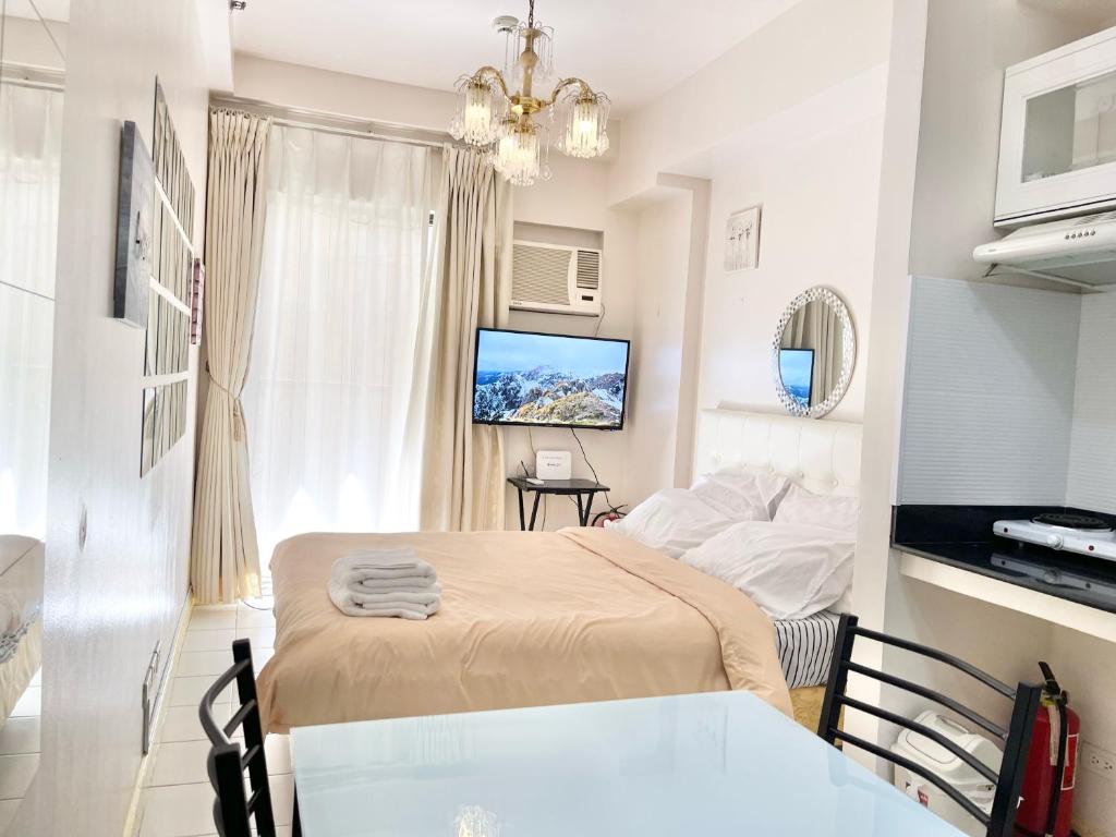 a bedroom with a bed and a television in it at Camella Northpoint Condo Studio in Davao City