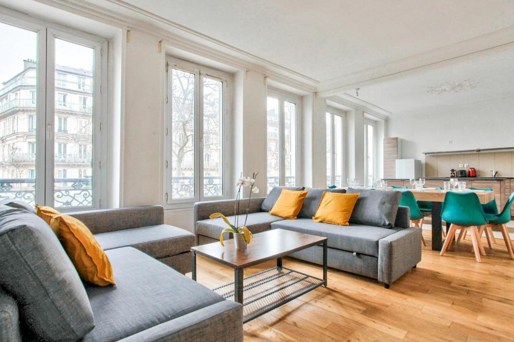 a living room with two couches and a table at Appartement Quartier Le Marais 2 in Paris