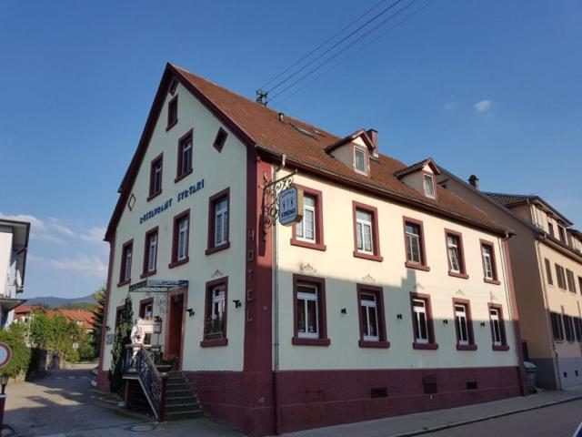 ein großes weißes und rotes Gebäude auf einer Straße in der Unterkunft Hotel Restaurant Syrtaki in Gernsbach
