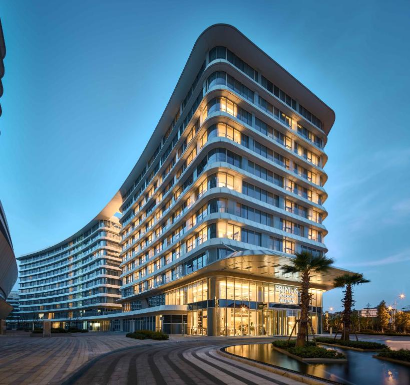 a large building with a palm tree in front of it at Primus Residence Shanghai Hongqiao in Shanghai